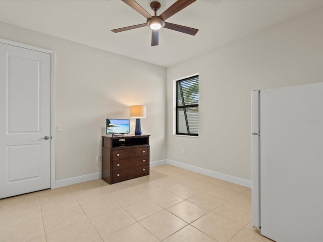 bedroom with ceiling fan, white fridge, and light tile patterned floors