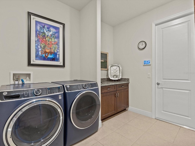 laundry area featuring cabinets, light tile patterned floors, and independent washer and dryer