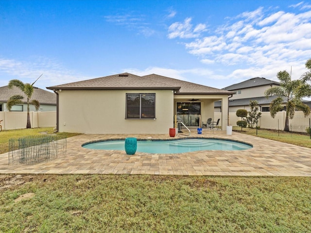 back of house with a fenced in pool, a yard, a patio, and ceiling fan