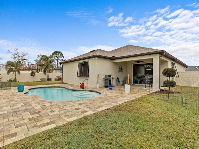 back of property featuring ceiling fan, a yard, a fenced in pool, and a patio