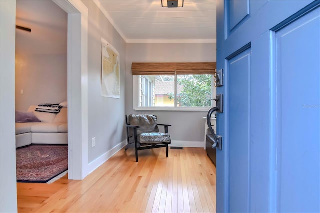 living area featuring ornamental molding and light hardwood / wood-style floors