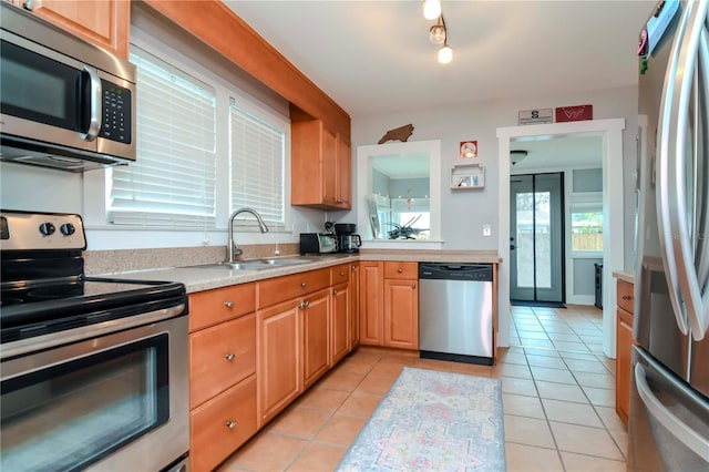 kitchen featuring sink, light tile patterned floors, and stainless steel appliances