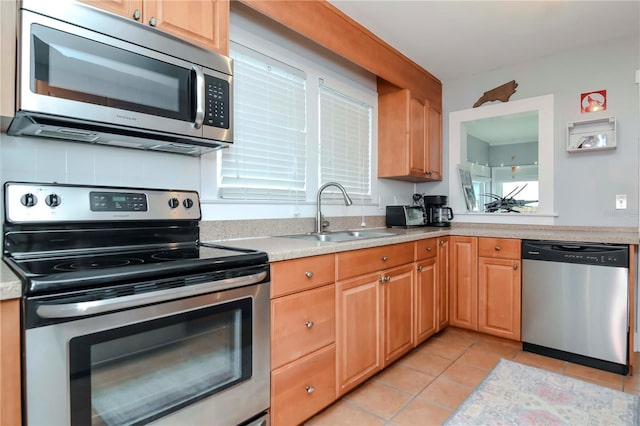 kitchen with sink, stainless steel appliances, and light tile patterned flooring