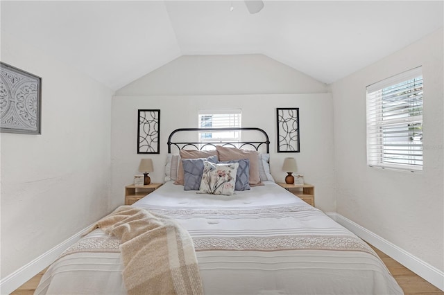 bedroom with ceiling fan, lofted ceiling, light hardwood / wood-style flooring, and multiple windows