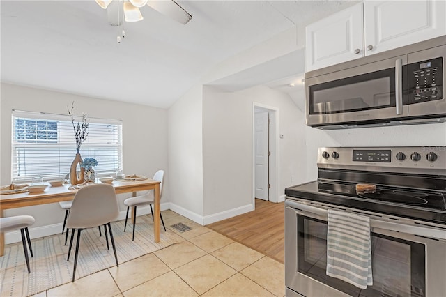 kitchen with white cabinets, lofted ceiling, stainless steel appliances, ceiling fan, and light tile patterned floors