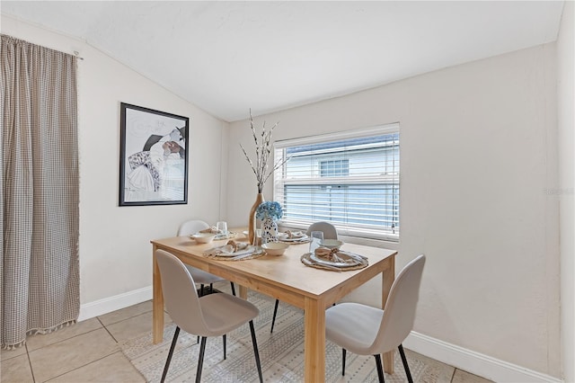 dining space featuring lofted ceiling and light tile patterned flooring