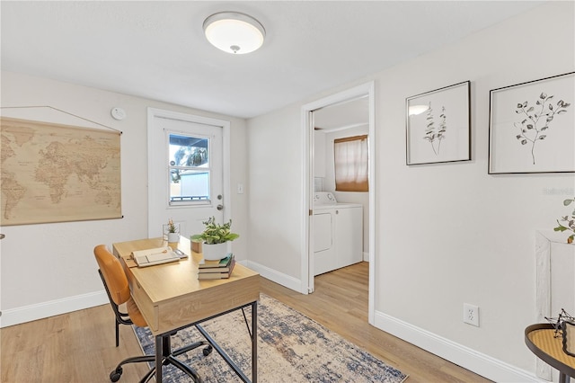 office area with washing machine and clothes dryer and light hardwood / wood-style floors