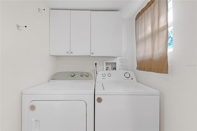 washroom with cabinets and washing machine and clothes dryer