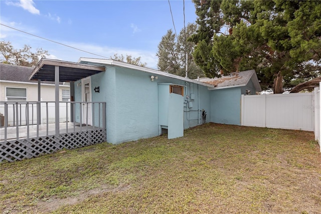 back of house with a wooden deck and a yard