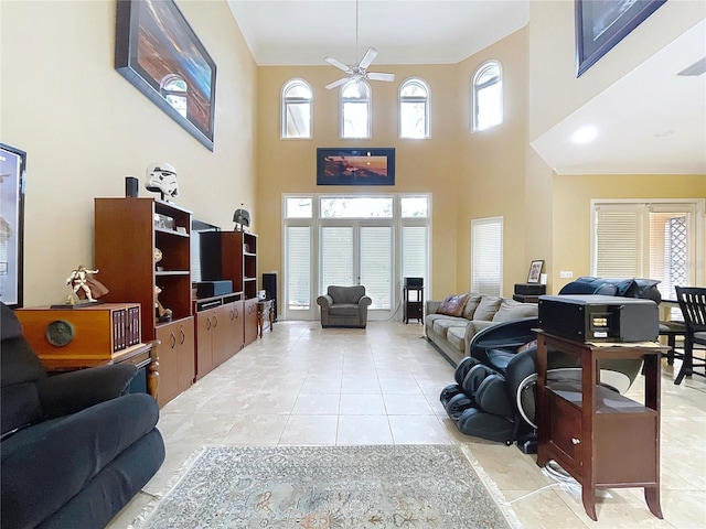 tiled living room with ceiling fan, a healthy amount of sunlight, and a high ceiling