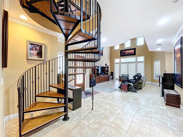 staircase with ornamental molding and tile patterned flooring