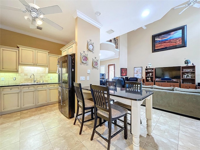 interior space featuring light tile patterned floors, tasteful backsplash, fridge, ornamental molding, and sink