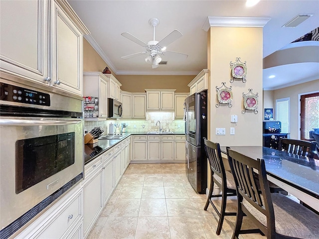 kitchen featuring appliances with stainless steel finishes, tasteful backsplash, sink, light tile patterned flooring, and crown molding