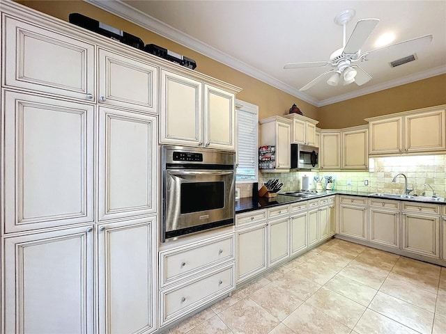 kitchen featuring tasteful backsplash, sink, stainless steel appliances, ornamental molding, and cream cabinetry