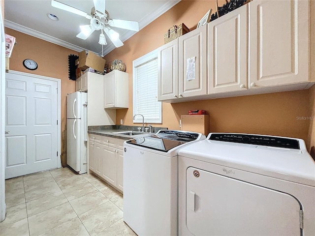 washroom featuring cabinets, sink, ornamental molding, and washing machine and dryer