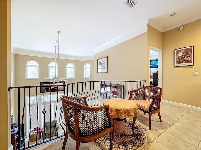 living area with light tile patterned floors and crown molding