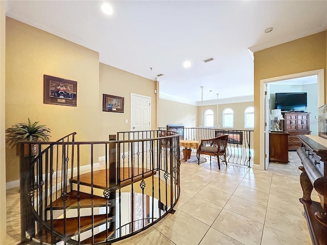 corridor featuring light tile patterned floors and ornamental molding