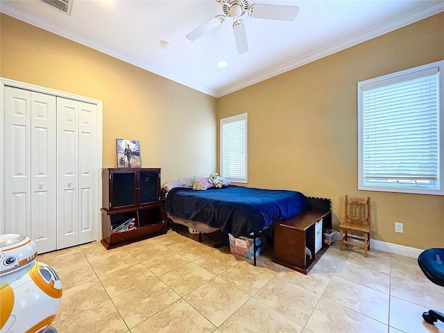 bedroom featuring ceiling fan, light tile patterned floors, a closet, and crown molding