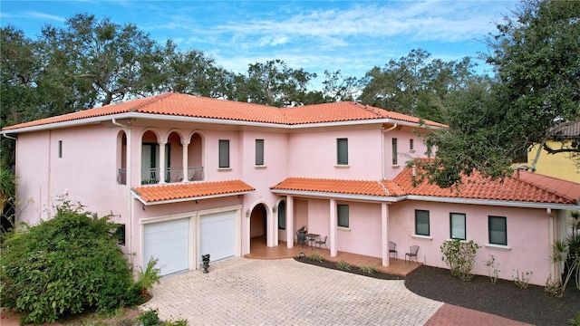 mediterranean / spanish home with a garage and a balcony