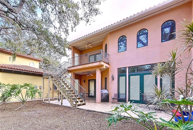 back of property featuring ceiling fan, a balcony, and a patio