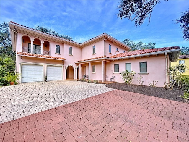 mediterranean / spanish house featuring a garage and a balcony