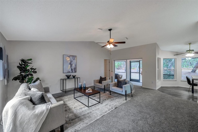 living room featuring ceiling fan, dark carpet, a textured ceiling, and vaulted ceiling