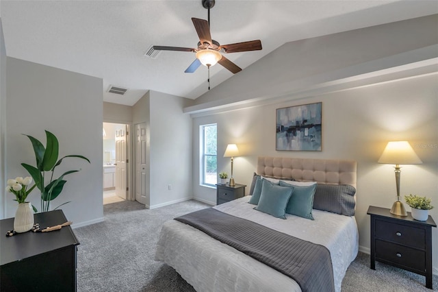 bedroom featuring ceiling fan, light colored carpet, lofted ceiling, and ensuite bath