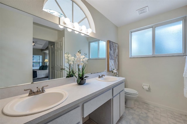 bathroom with toilet, ceiling fan, and vanity