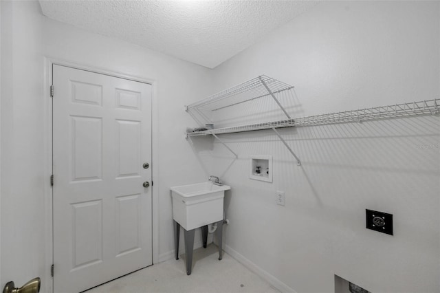 clothes washing area with light colored carpet, washer hookup, electric dryer hookup, and a textured ceiling