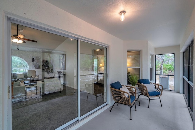 sunroom featuring ceiling fan and plenty of natural light