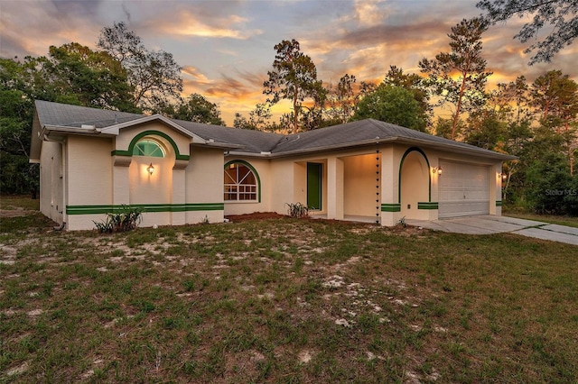 ranch-style home with a garage and a lawn