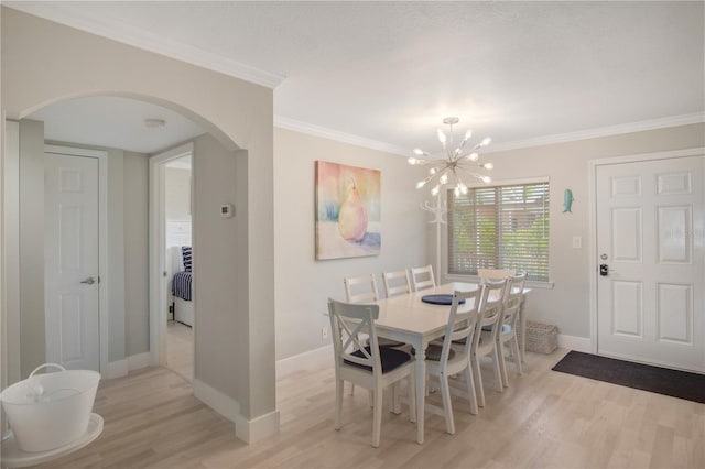 dining room with light hardwood / wood-style floors, crown molding, and a chandelier