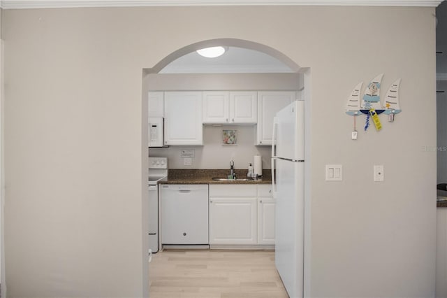 kitchen featuring sink, white appliances, white cabinets, and ornamental molding