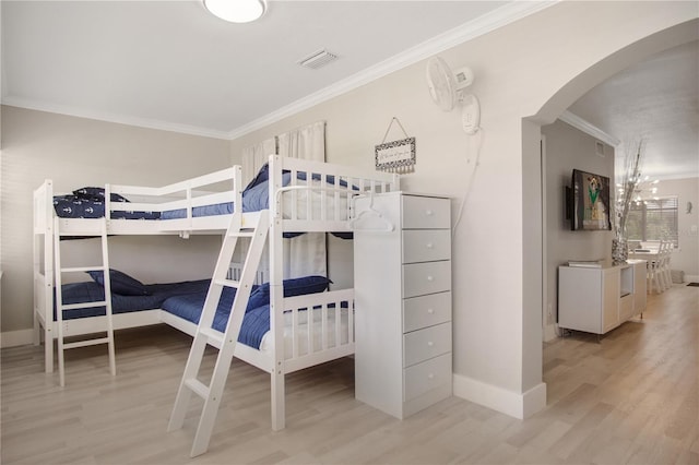 bedroom featuring light wood-type flooring and crown molding