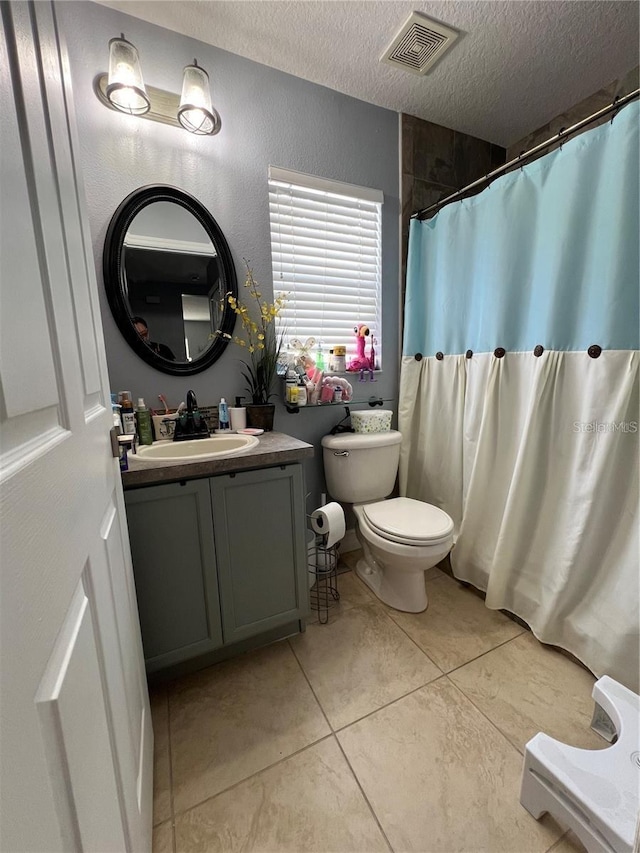 bathroom featuring vanity, a textured ceiling, a shower with curtain, tile patterned floors, and toilet