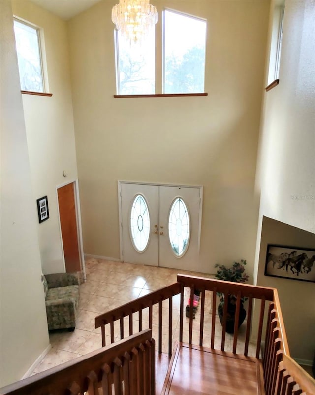 tiled foyer with a high ceiling and a chandelier