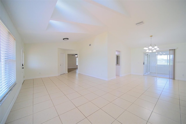 tiled empty room with a chandelier and vaulted ceiling