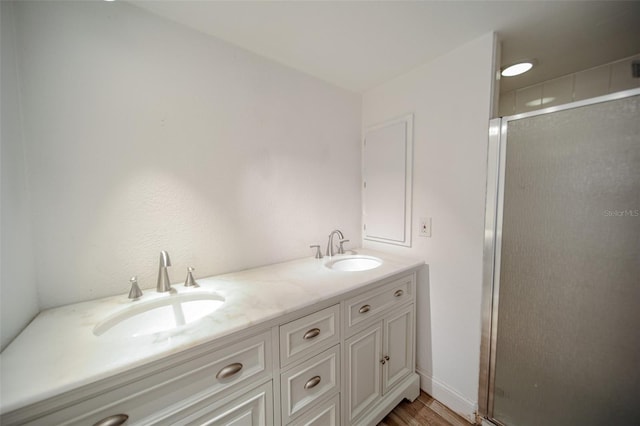 bathroom featuring walk in shower, hardwood / wood-style flooring, and vanity