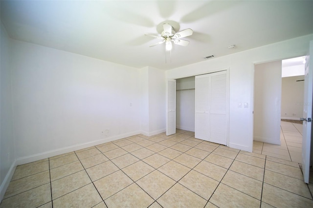 unfurnished bedroom featuring ceiling fan, light tile patterned floors, and a closet