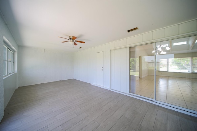 interior space featuring ceiling fan with notable chandelier and a wealth of natural light