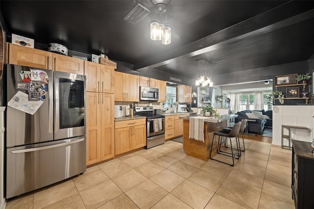 kitchen featuring light tile patterned flooring, light brown cabinets, stainless steel appliances, and an inviting chandelier