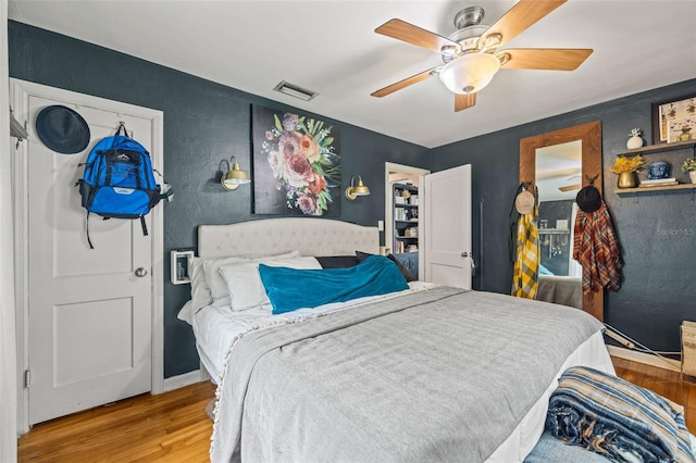 bedroom with ceiling fan and light hardwood / wood-style floors