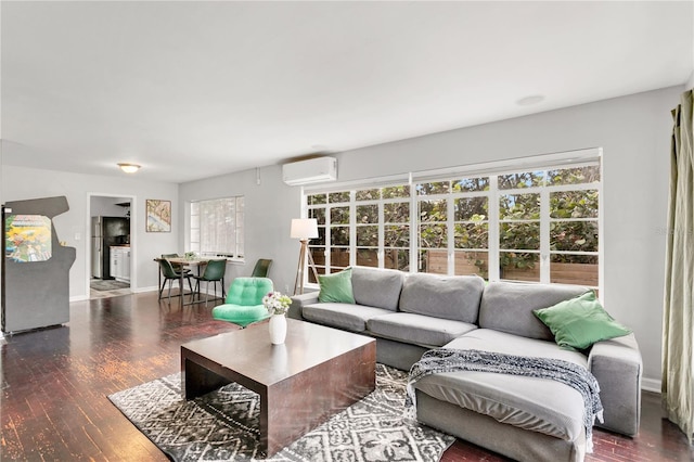 living room featuring dark wood-type flooring, a healthy amount of sunlight, and an AC wall unit