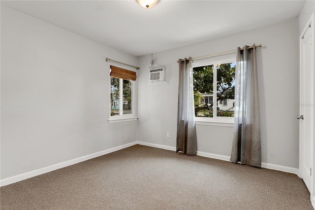 empty room with carpet floors, a wall mounted AC, and a wealth of natural light