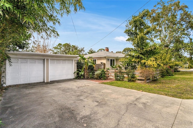 ranch-style house with a garage and a front lawn