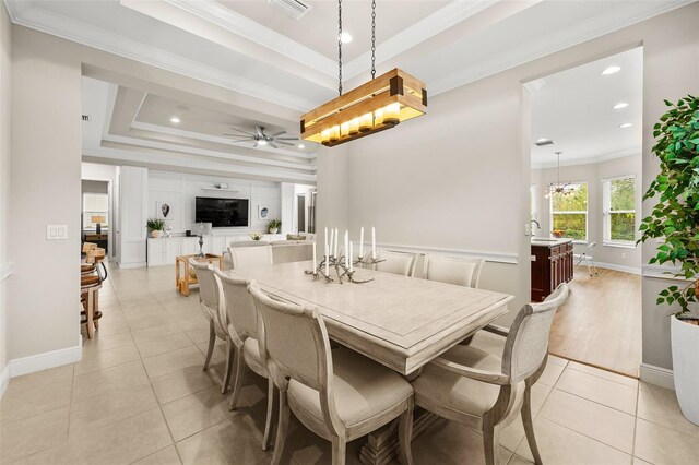 dining room featuring a tray ceiling, visible vents, ornamental molding, a ceiling fan, and light tile patterned flooring