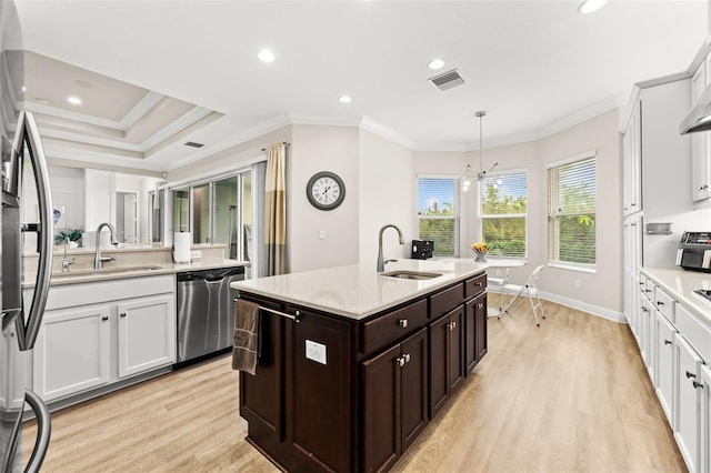 kitchen featuring a sink, visible vents, ornamental molding, appliances with stainless steel finishes, and light wood finished floors