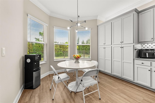 dining space with light wood-type flooring, baseboards, and ornamental molding