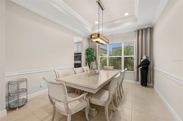 dining room featuring light tile patterned floors, baseboards, a tray ceiling, and crown molding