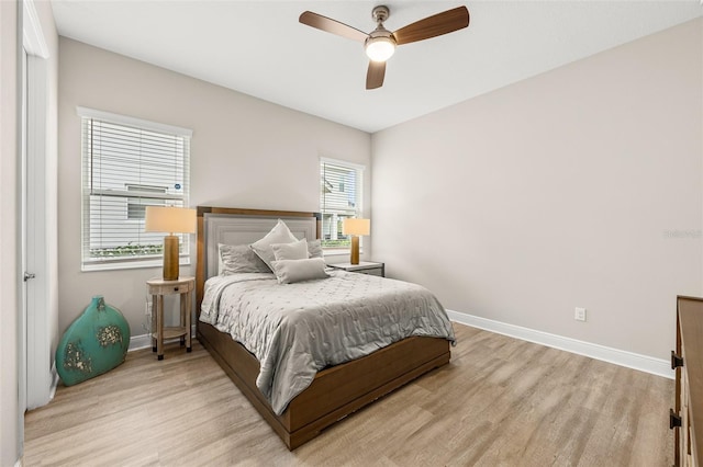 bedroom featuring light wood-style flooring, baseboards, and ceiling fan